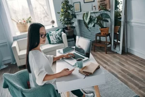 Woman working at desk with laptop and coffee